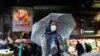 An Iranian woman wears a protective face mask and gloves, amid fear of coronavirus disease (COVID-19), as she walks at Tajrish market, ahead of the Iranian New Year Nowruz, in Tehran, March 18, 2020