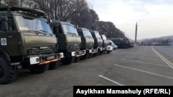 Police cars, trucks and buses line up near the Independence Monument in Almaty on December 16.