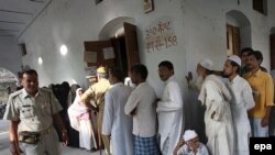 Voters wait outside a polling station in Varanasi.