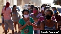 Люди в масках на окраине бразильской столицы. 2 августа 2020 года.
