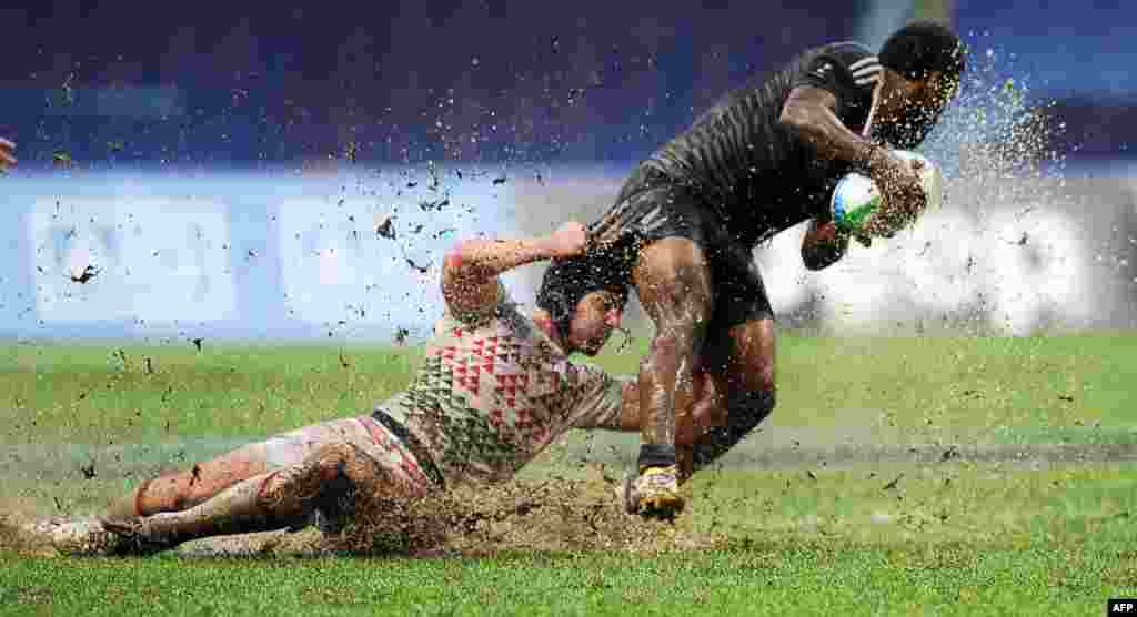 England's Rob Vickerman (left) tackles New Zealand's Tomasi Cama during the final match of the 2013 Rugby World Cup Sevens tournament between New Zealand and England at the Luzhniki stadium in Moscow. (AFP/Yuri Kadobnov)