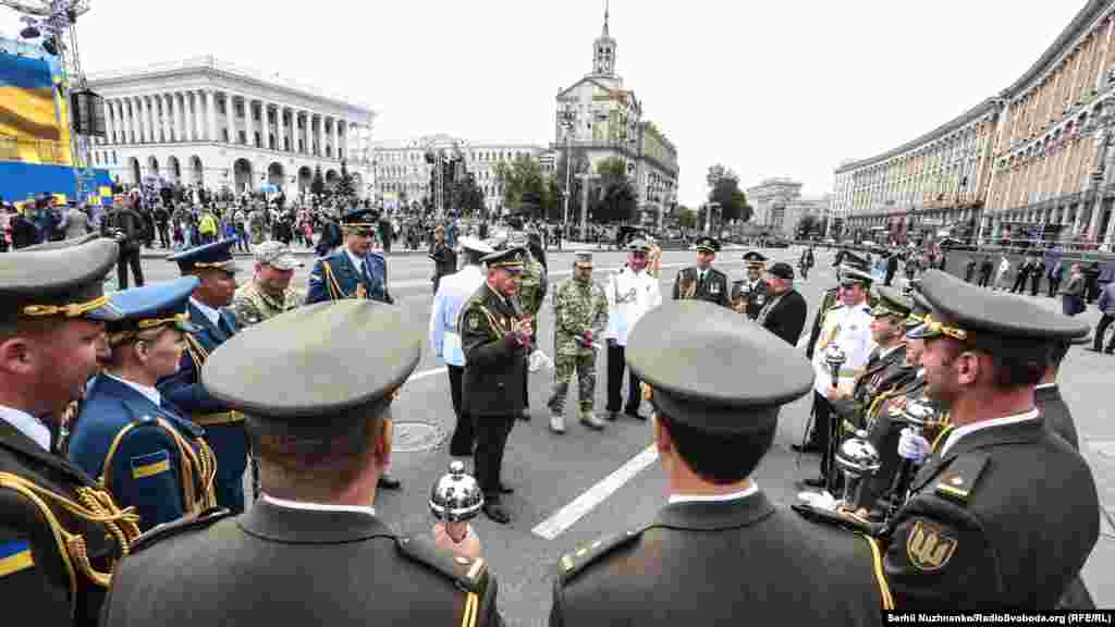 Українські військові з різних підрозділів спілкуються після військового параду 