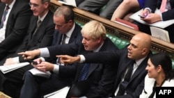 Sadžid Džavid (desno) pokazuje prstom u britanskom parlamentu, pored premijera Borisa Džonsona (levo), oktobar 2019. 