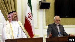 Iranian Foreign Minister Mohammad Javad Zarif (R) and his Qatari counterpart Khalid bin Mohamed Al Attiyah at a joint press conference in Tehran, February 26, 2014