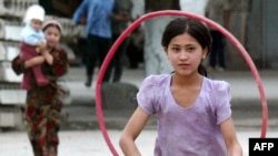 Девочки играют на улице города Андижана 18 мая 2005 года. 