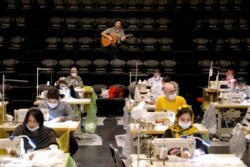 اجرای گیتار در سالن تولید داوطلبانه ماسک در تهران