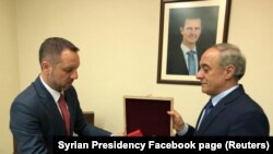 Сирия президентінің Facebook-тегі парақшасында жарияланған сурет. Сирия Сыртқы істер министрлігінің өкілі Дамаскідегі Румыния елшілігіне Құрмет легионының кавалері орденін қайтару сәті. 19 сәуір 2018 жыл.