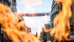 Vječna vatra u Sarajevu i plakat na kojem piše Ja sam antifašista tokom protesta protiv mise za žrtve u Blajburgu koja je održana u katedrali u Sarajevu