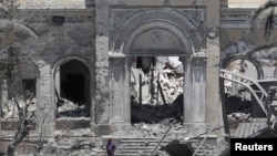 A man walks near the parliament building in Tripoli, which official say was damaged by coalition air strikes.