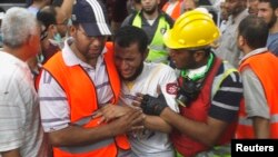 Medical volunteers and supporters of deposed Egyptian President Muhammad Morsi comfort a man who lost a relative during clashes with police, at a field hospital in the Nasr city area east of Cairo on July 27.