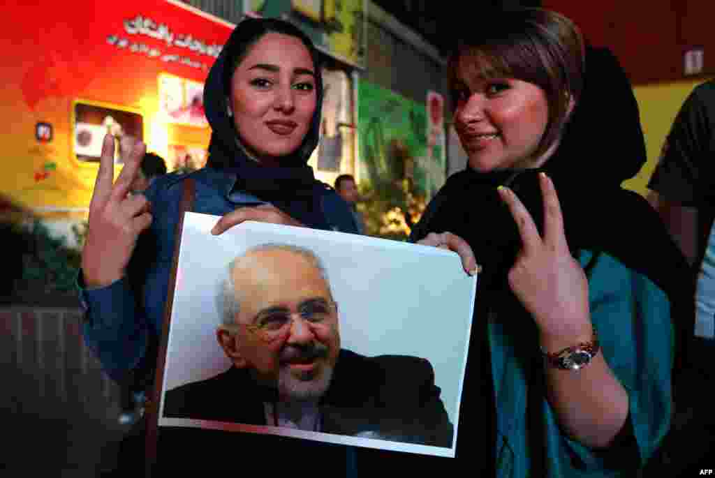 Women hold a portrait of Iranian Foreign Minister Mohammad Javad Zarif, who announced the agreement in Vienna.