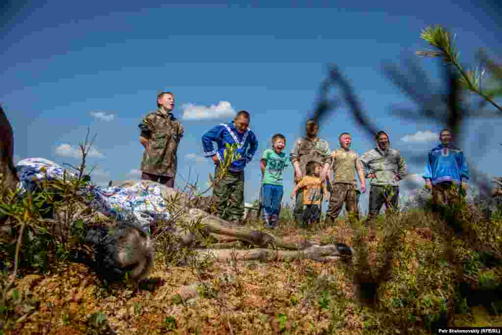 Family members gather around the sacrificed reindeer.