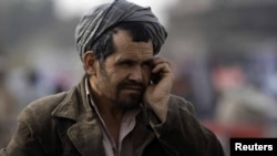 Қол телефонмен сөйлесіп тұрған ер адам, Кабул, Ауғанстан, 24 наурыз 2011 жыл.
