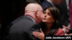 Russian Ambassador to the United Nations Vasily Nebenzya, left, and United States Ambassador to the U.N. Nikki Haley exchange greetings before a Security Council meeting, at U.N. headquarters in New York, April 10, 2018