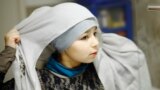 Sanaa, 10 ani, își pune hijab-ul înainte de a intra la Scoala Islamică de Sâmbătă, Leyton, estul Londrei, 9 noiembrie 2013. Mama ei spunea atunci că de la 11 ani Sanna va trebui să poarte obligatoriu zilnic hijab-ul, dar doar dacă asta va fi alegerea ei. 