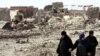 Women in Mosul walk through rubble at the site of a bomb attack in September.