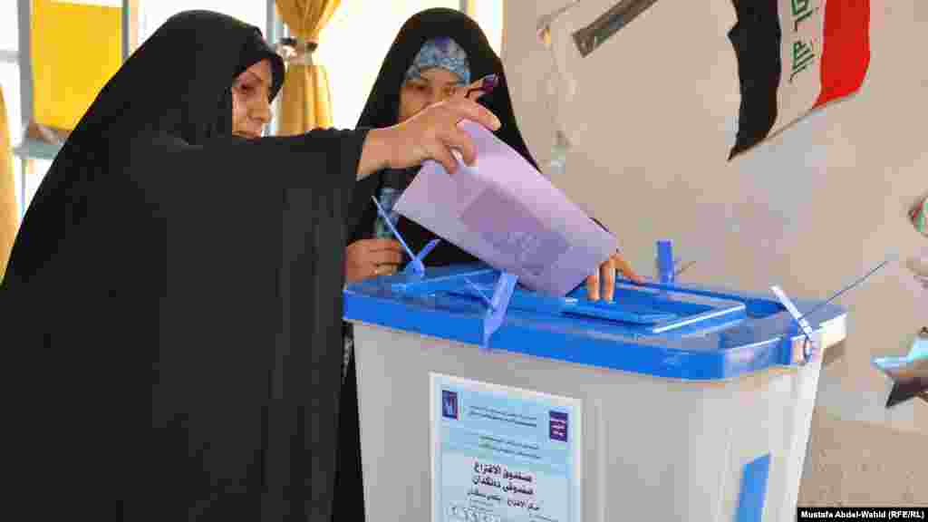 A woman casts her ballot in Karbala.