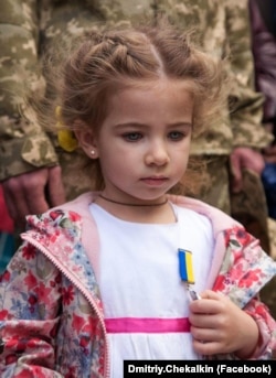 Олександра Матвієнко, якій на цьому фото три з половиною років, із медаллю батька, воїна Андрія Матвієнка, який загинув на Донбасі, захищаючи Україну від російської агресії. Кропивницький, 8 травня 2015 року