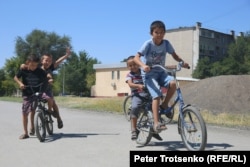 Дети катаются на велосипедах по городским улицам. Кентау, 22 августа 2018 года