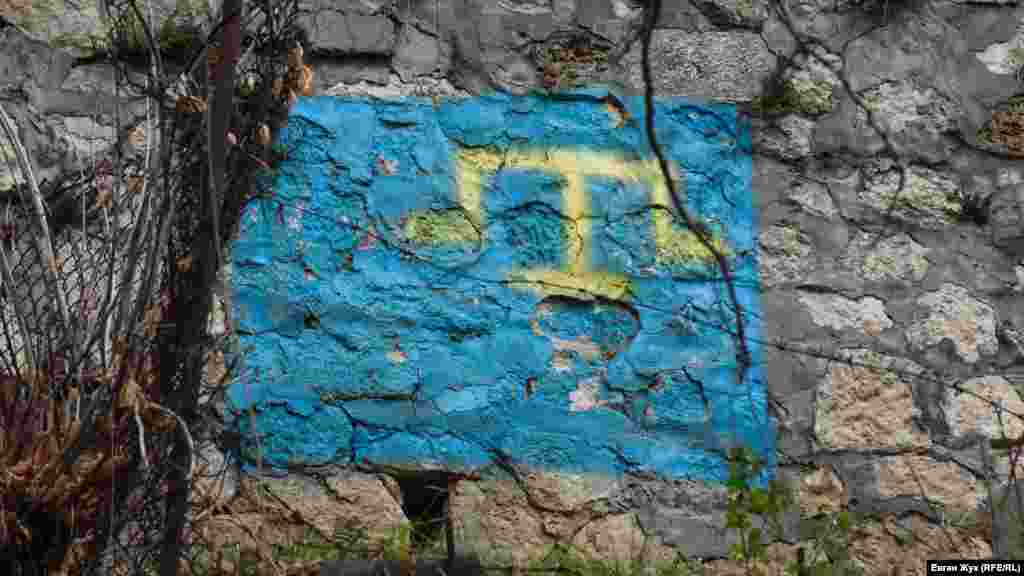 Divarda qırımtatar bayrağı şeklinde graffiti. Taraq tamğa &ndash; Qırım hanları Geraylarnıñ sülâle tamğasıdır, bugünde-bugün qırımtatarlarnıñ milliy timsali olaraq qullanılmaqtadır