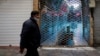 An Iranian man wearing a face mask walks past a closed shopping mall at a bazaar in Tehran earlier this year. 