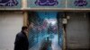 An Iranian man wearing a face mask walks past a closed shopping arcade in Tehran's Tajrish bazaar. April 10, 2020