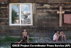 Roma children rest in the shade of a church wall inside an encampment on the outskirts of Uzhhorod in western Ukraine. (file photo)