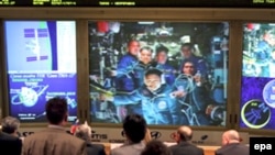 На екрані в російському Центрі управління польотами Сергій Волков на МКС у середньому ряду праворуч, фото 10 квітня 2008 року
