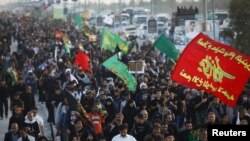 Shi'ite Muslim pilgrims walk to the holy city of Kerbala, ahead of the holy Shi'ite ritual of Arbaeen, in Najaf, November 30, 2015