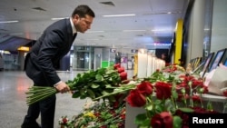 Ukrainian President Volodymyr Zelenskiy lays flowers at a memorial to the crash victims at Kyiv's Boryspil International Airport.