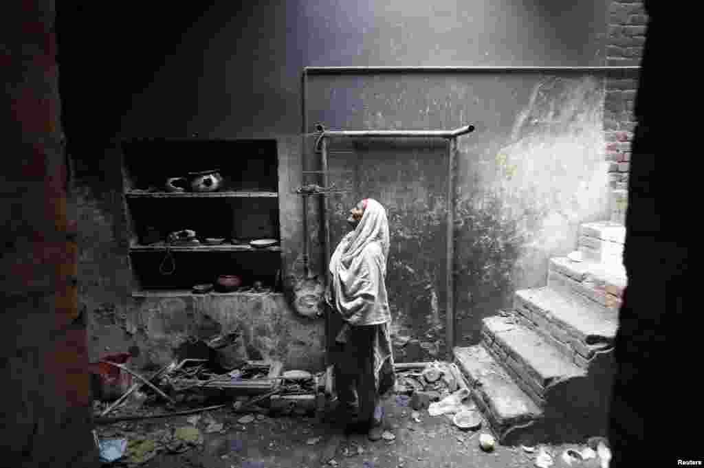 Azra, 68, looks at her dead pet bird in a cage at her home, which was burnt by a mob two days earlier, in Lahore, Pakistan. Hundreds of Pakistani Christians took to the streets across the country, demanding better protection after a Christian neighborhood was torched in connection with the country's controversial antiblasphemy law. (Reuters/Mohsin Raza)