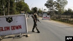 Indian army soldiers stand guard at the entrance to an army camp in Baramulla, some 50 kilometers northwest of Srinagar, on October 3.