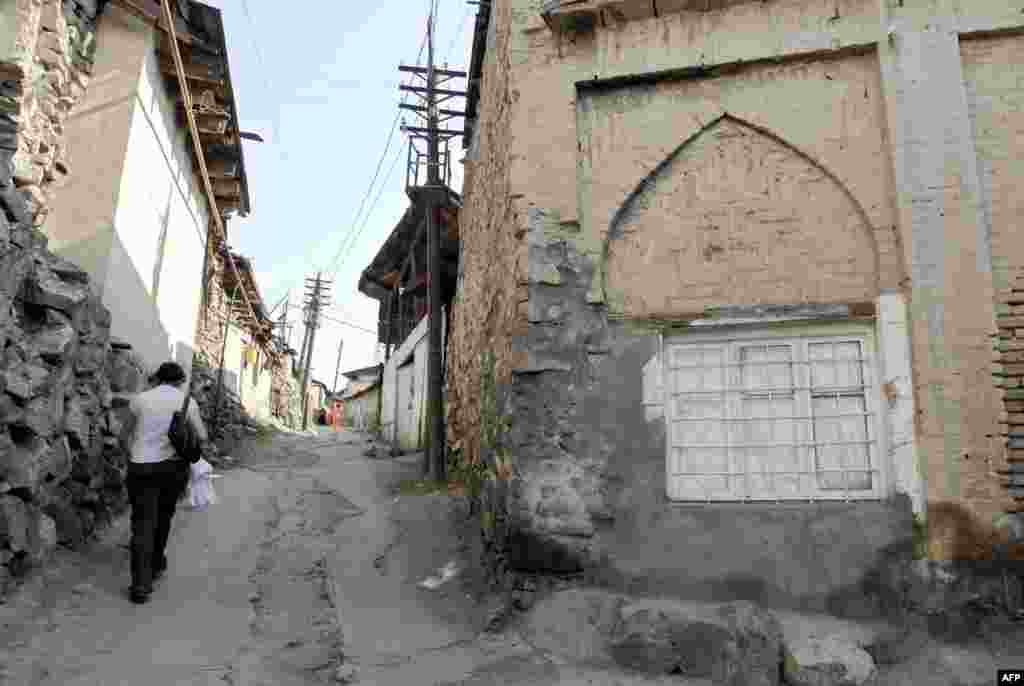 A woman walks along a street through the historical Kond district in the western part of the city.