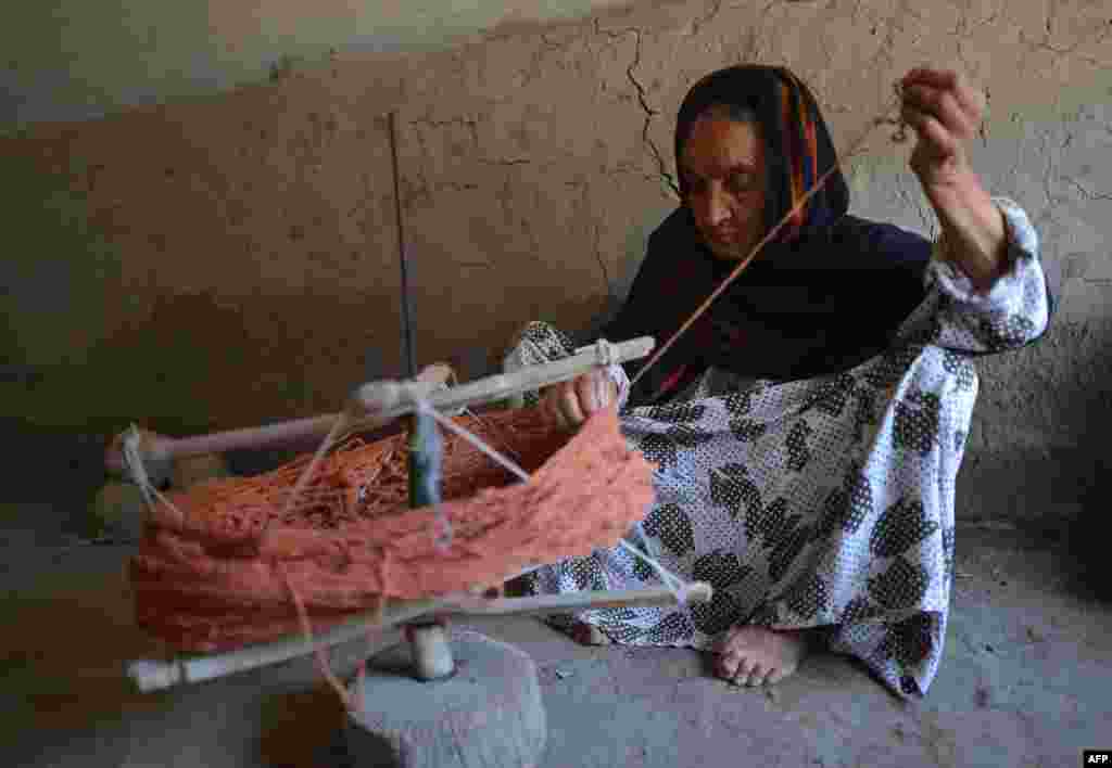 An Afghan refugee prepares thread for carpet weaving at the Khorasan refugee camp near Peshawar. (AFP/A. Majeed)