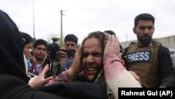 FILE: Family members cry after an attack on a Sikh Gudwara in the capital Kabul on March 25.