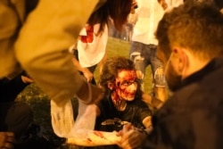 A wounded protester is tended to while awaiting an ambulance.