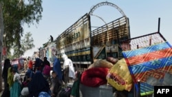 FILE: Afghan refugee families gather next to their belongings at the United Nations High Commissioner for Refugees (UNHCR) repatriation center on the outskirts of Peshawar in April.
