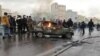 Iranian protesters gather around a burning car during a demonstration against an increase in gasoline prices in the capital Tehran, on November 16, 2019.