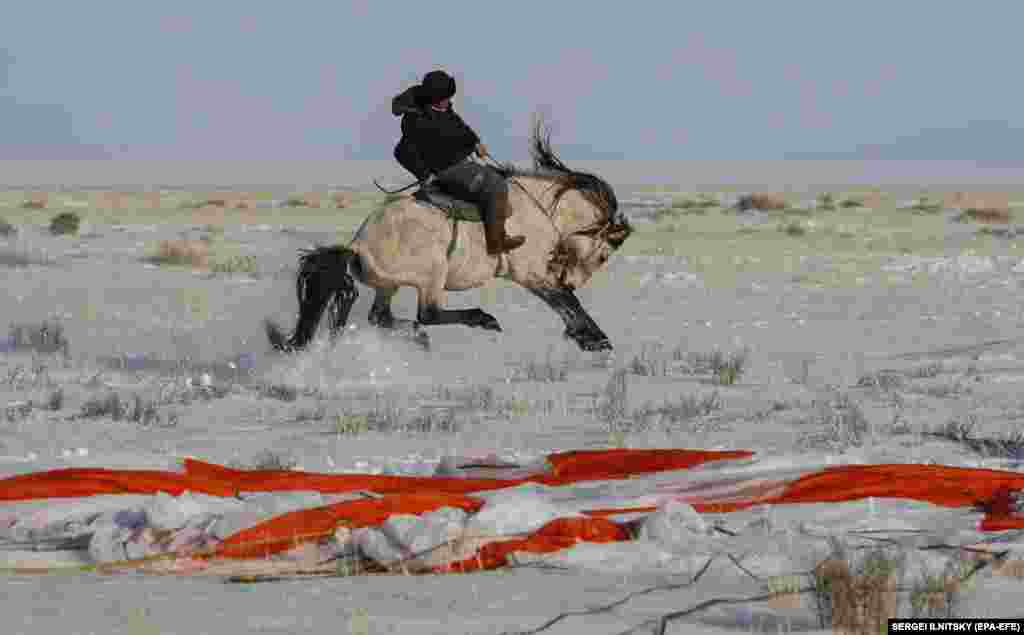 A Kazakh shepherd rides his horse near the place where the Russian Soyuz MS-13 space capsule landed about 120 kilometers southeast of the town of Zhezkazgan, returning NASA astronaut Christina Koch, ESA astronaut Luca Parmitano, and cosmonaut Aleksandr Skvortsov of Roscosmos to Earth on the Kazakh steppe after a mission aboard the International Space Station. (epa-EFE/Sergei Ilnitsky)