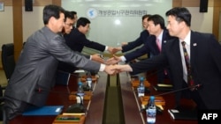 North and South Korean delegates shake hands during a meeting at the Kaesong industrial complex on September 11.