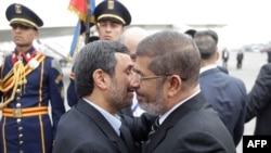 Deposed Egyptian President Muhammad Morsi (right) greets Iranian President Mahmud Ahmadinejad in Cairo in February.