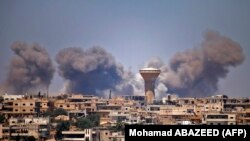 SYRIA -- Smoke rises above rebel-held areas of the city of Daraa during reported airstrikes by Syrian regime forces on July 5, 2018.