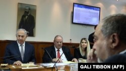 Israeli Prime Minister Benjamin Netanyahu (L) sits across from Defense Minister Avigdor Lieberman as he chairs a weekly cabinet meeting. File photo
