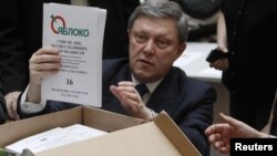 Yabloko party founder Grigory Yavlinsky opens a box of signatures supporting his presidential candidacy at the Central Election Commission in Moscow on January 18. 