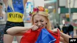 U.S. - Inna Shevchenko rips a Russian flag as she joins topless activists of the Ukrainian protest group Femen demonstrates against Russian intervention in Ukraine and in support of US sanctions on March 6, 2014 in New York's Times Square.