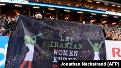 (FILE) Supporters hold a banner reading 'Let Iranian women enter their stadiums' during the friendly international football match between Sweden and Iran near Stockholm, March 31, 2015
