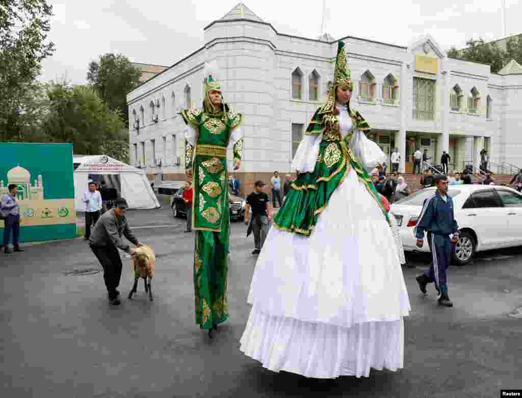 Артисты на ходулях рядом с центральной мечетью Алматы.