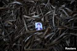 A passport photo left behind by a migrant is seen among seaweed on a beach on the Greek island of Lesbos.