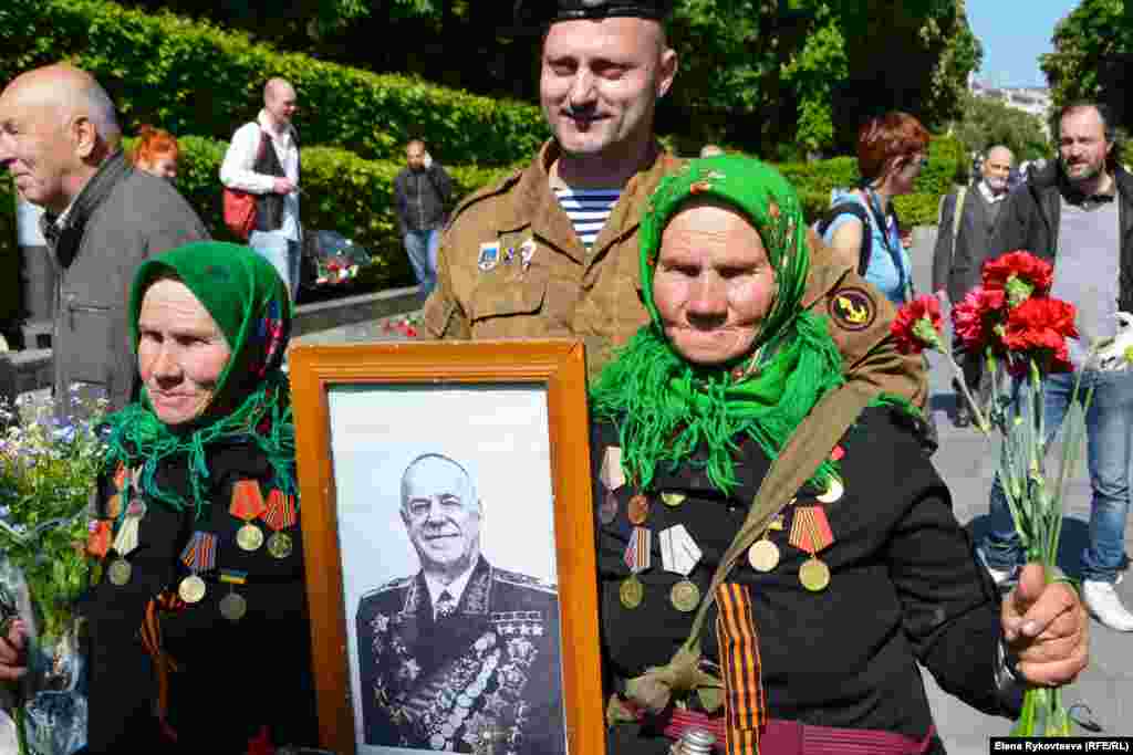 Two women in Kyiv, Ukraine, hold a portrait of former Red Army commander and World War II hero Georgy Zhukov, the most decorated officer in Soviet history.