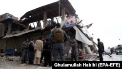 Afghan security officials inspect the scene of a bomb blast in Jalalabad on February 20.